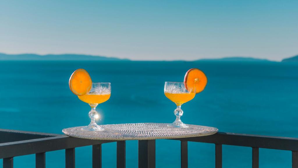 two glasses of orange juice sitting on a table at Apartments Spalato in Podstrana