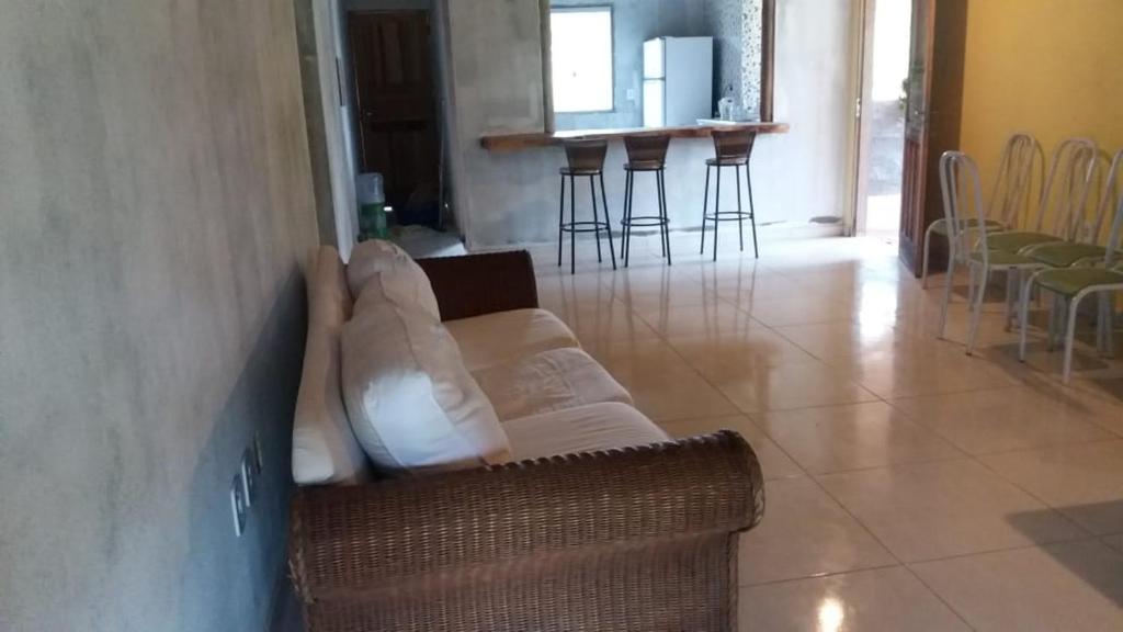 uma sala de estar com um sofá e algumas cadeiras em Chale do vale em Porto Seguro