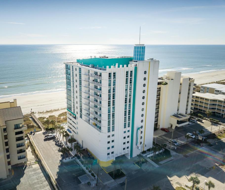 eine Luftansicht auf ein hohes weißes Gebäude neben dem Strand in der Unterkunft Seaside Resort in Myrtle Beach