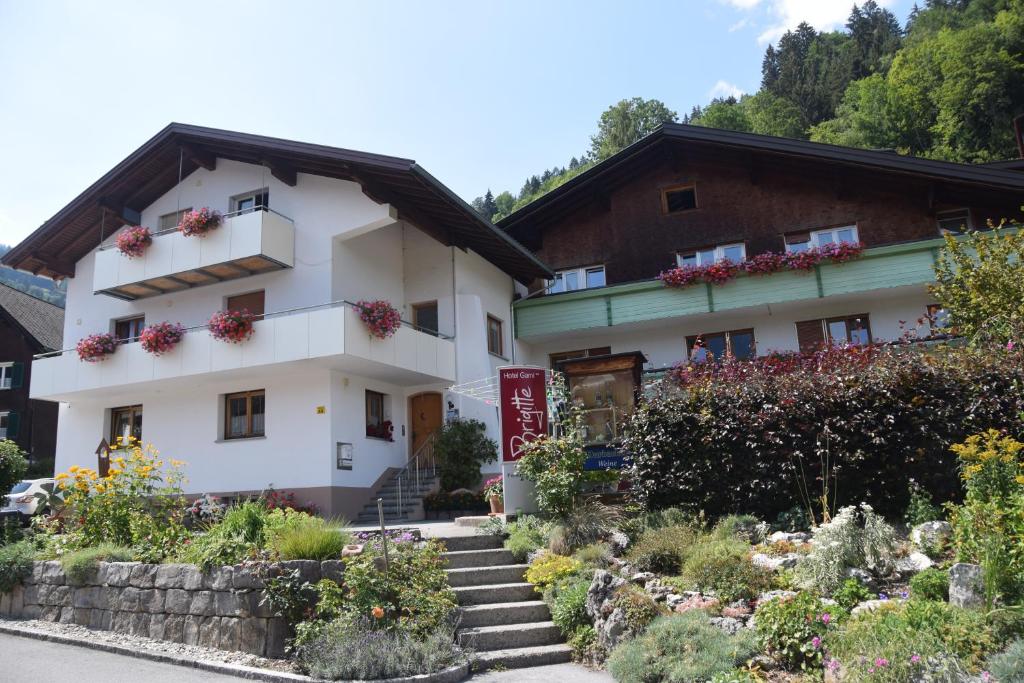 un edificio blanco con flores en los balcones en Hotel Garni Brigitte, en Bürserberg