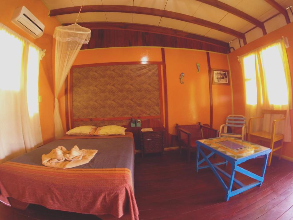 
a bedroom with a bed and a table in it at Hotel Maritza in Puerto Viejo
