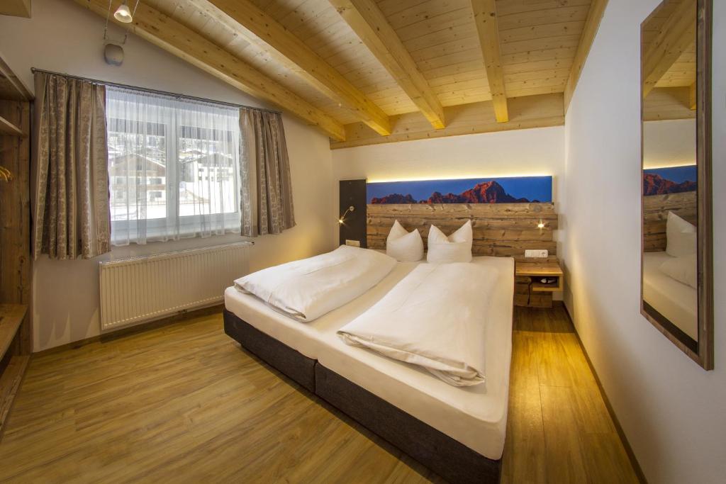 ein Schlafzimmer mit großem Bett und Fenster in der Unterkunft Haus Mariandl in Nesselwängle