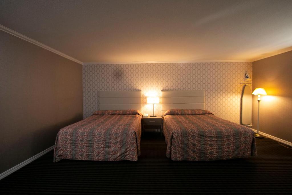 Postel nebo postele na pokoji v ubytování Alpha Inn and Suites