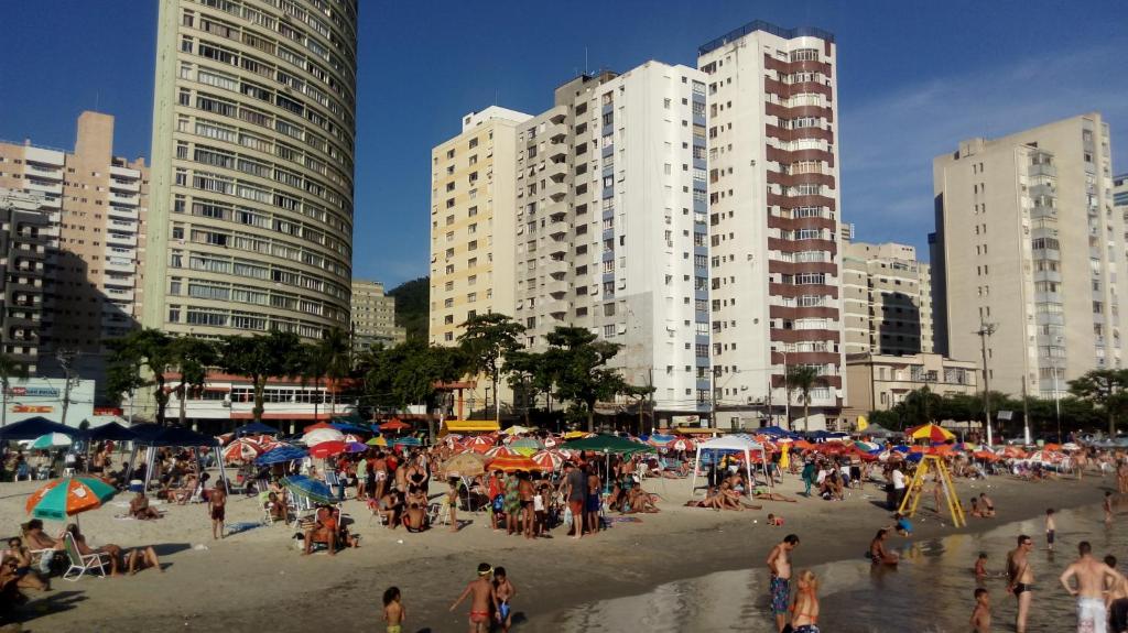 a group of people on a beach with buildings at AUDAX MARAVILHA in São Vicente