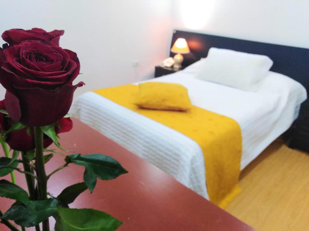 a bedroom with a bed and a rose on a table at Hotel Lagos Latin America in Pasto