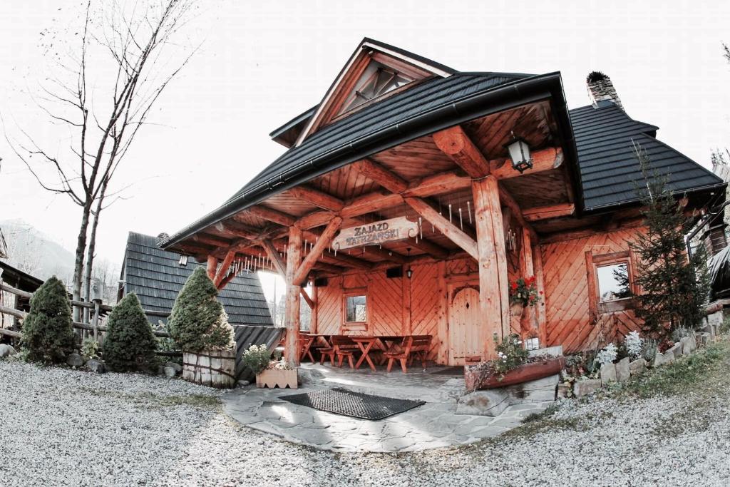 a log cabin with a black roof at Zajazd Tatrzanski in Kościelisko