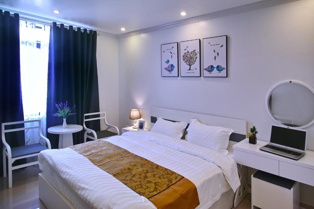 une chambre avec un lit, un bureau et un miroir dans l'établissement Thiên An Hotel, à Hai Phong