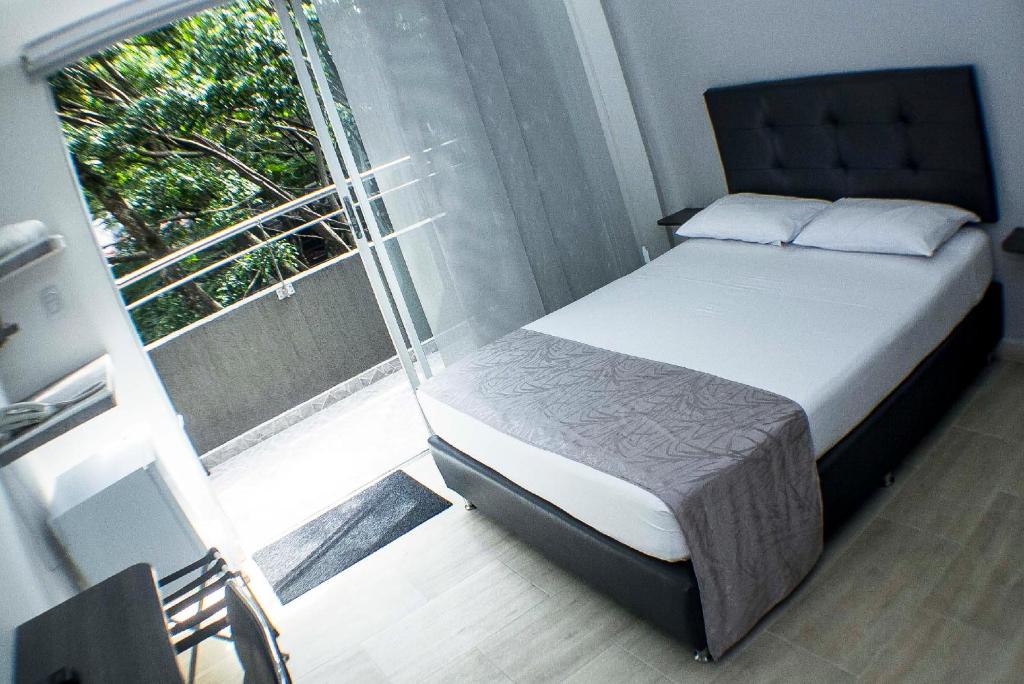- une chambre avec un lit et une grande fenêtre dans l'établissement Element Hotel, à Medellín