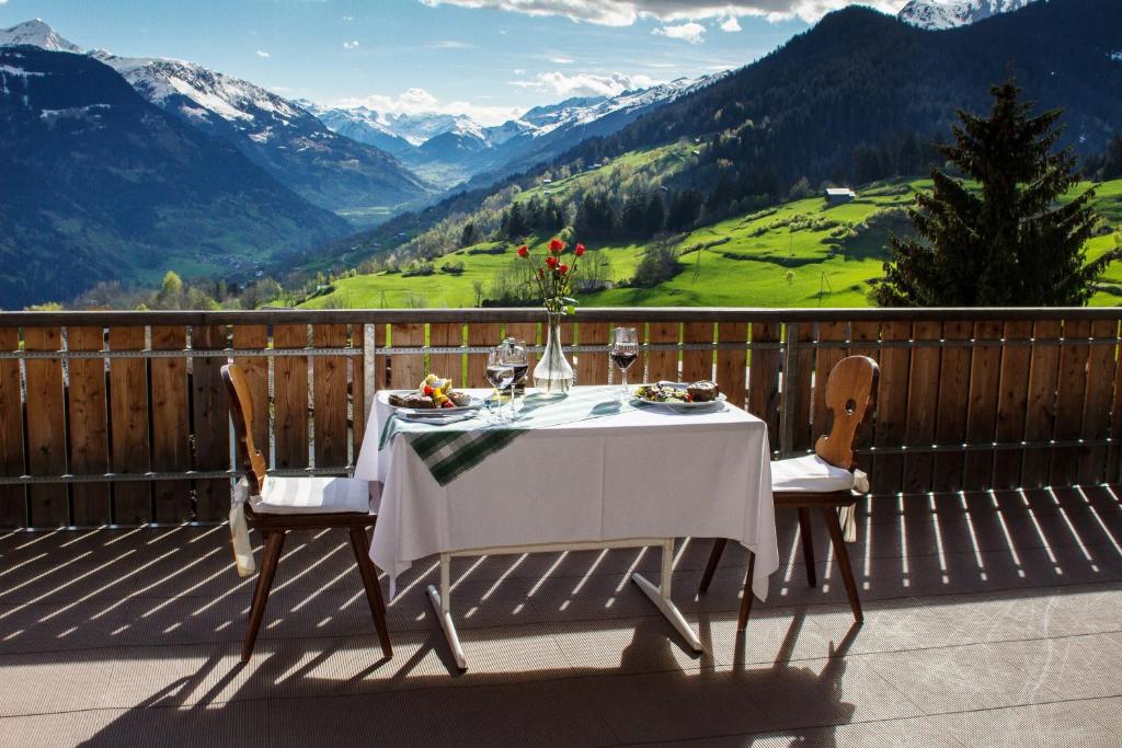 uma mesa numa varanda com vista para as montanhas em Hotel Kistenpass em Brigels