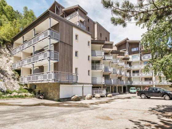 a large apartment building with a car parked in front of it at Le Kandahar Les 2 Alpes in Les Deux Alpes