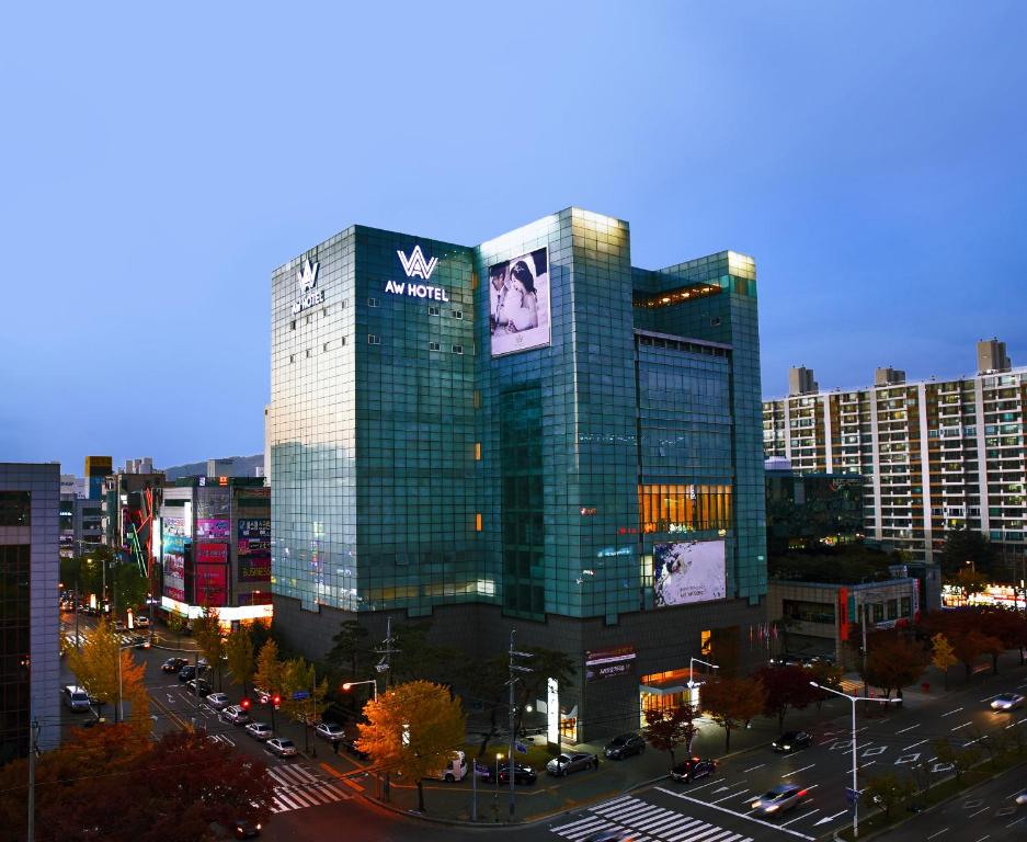 a tall building with a sign on it in a city at Daegu AW Hotel in Daegu