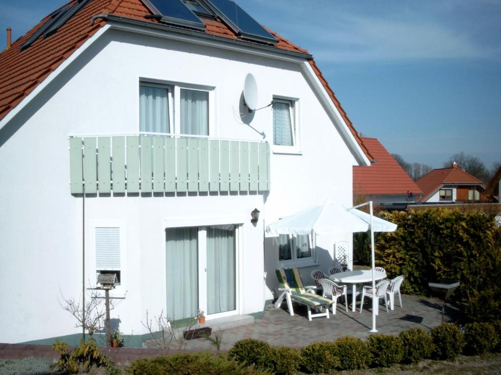 a white house with a patio and an umbrella at Ferienwohnung Klement in Neubukow