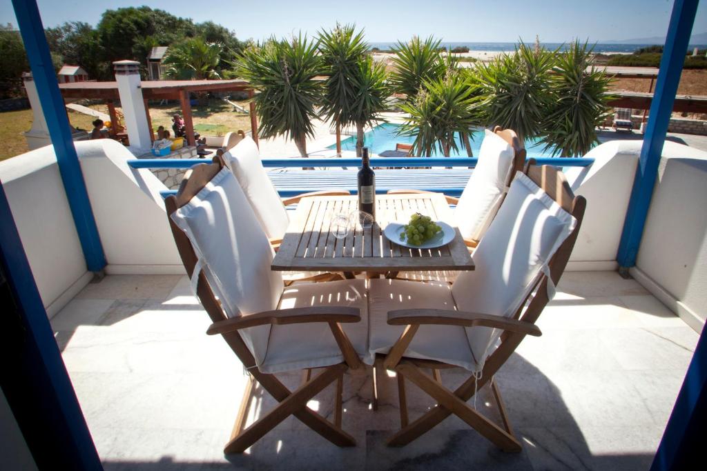 una mesa y sillas en un balcón con vistas al océano en Aeraki Studios en Kastraki
