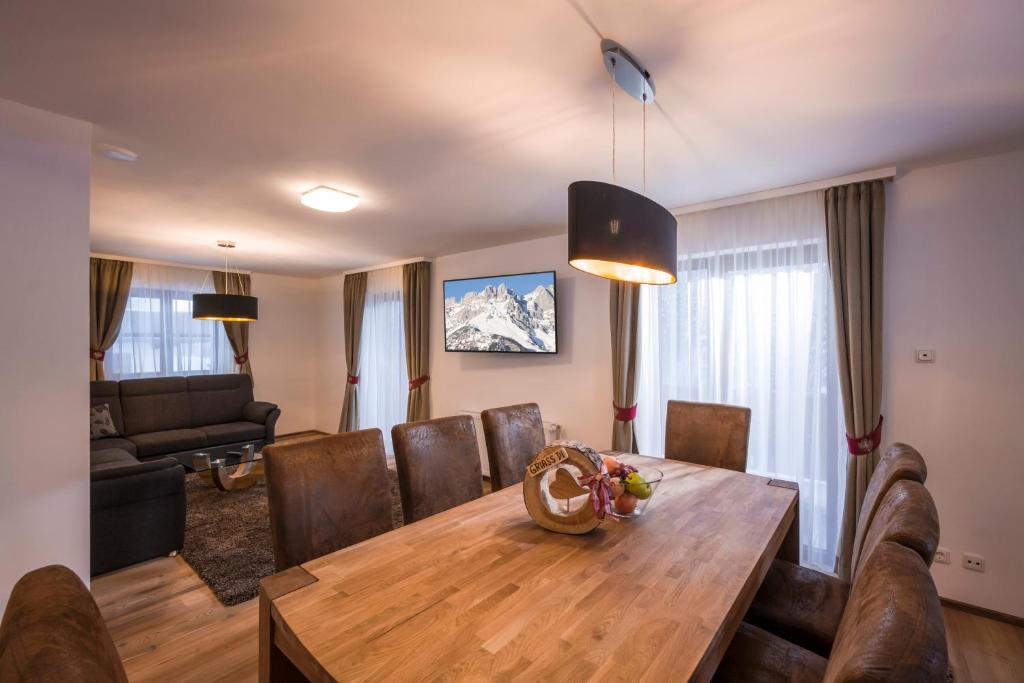 a living room with a wooden table and leather chairs at Kaiser Chalet in Going