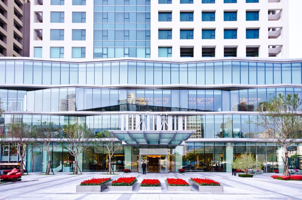 een groot glazen gebouw met een fontein ervoor bij Millennium Hotel Taichung in Taichung
