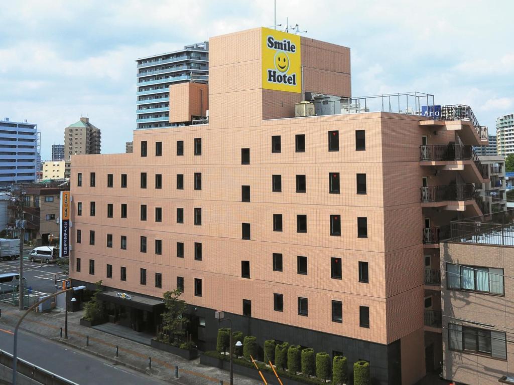 un edificio con un letrero amarillo encima en Smile Hotel Kawaguchi, en Kawaguchi