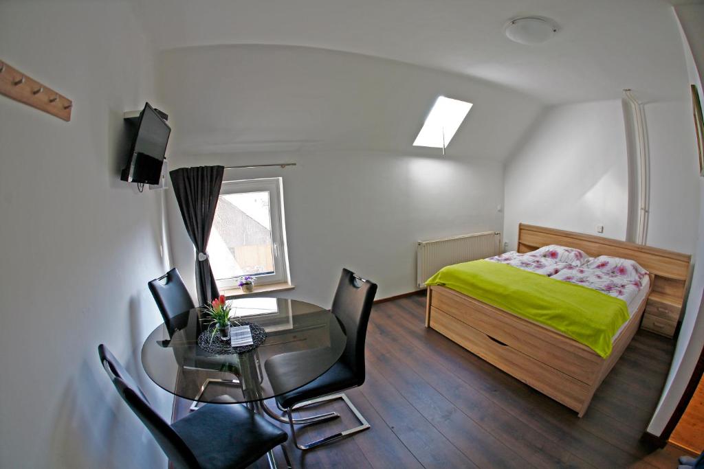 a bedroom with a bed and a desk and a table with chairs at Apartments Bernard in Bled