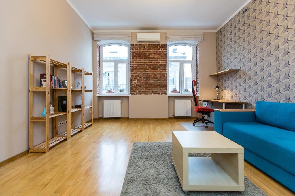 リヴィウにあるLight and spacious Apartment on Gazova Strの青いソファとレンガの壁が備わるリビングルーム