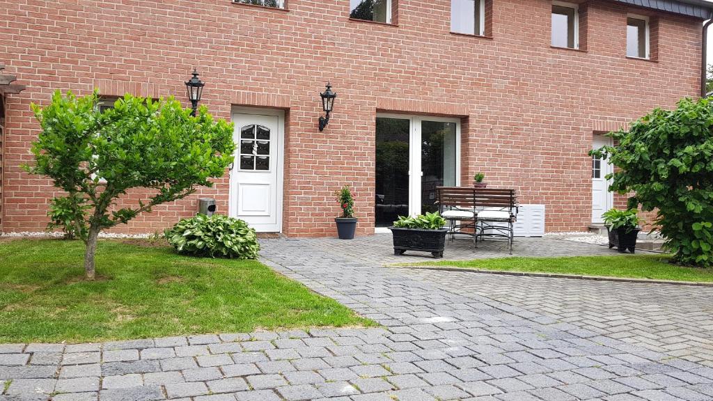 un bâtiment en briques avec une porte blanche et un banc dans l'établissement Zimmervermietung BredyGbR, à Querfurt