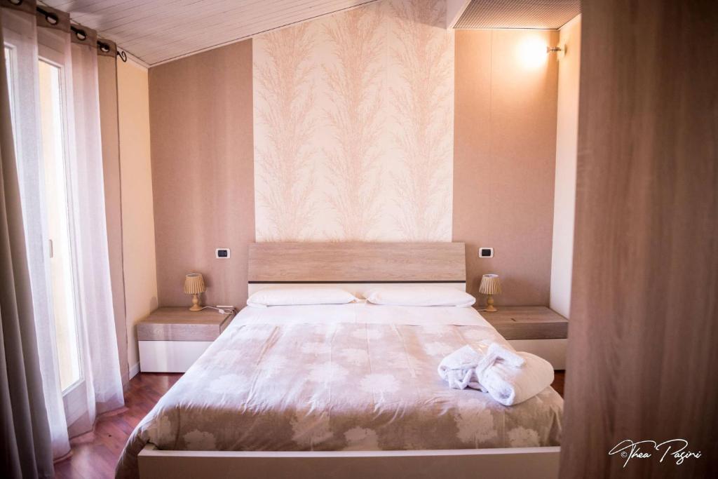 1 dormitorio con 1 cama grande y 2 ventanas en Hotel Lonatino en Lonato