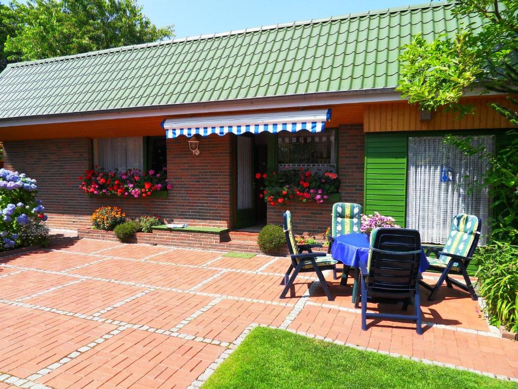 eine Terrasse mit einem Tisch und Stühlen vor einem Haus in der Unterkunft Ferienhaus von Bargen in Cuxhaven