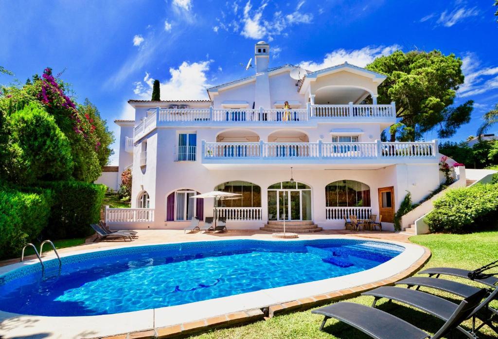 a villa with a swimming pool in front of a house at Villa Melissa by Rafleys in Marbella