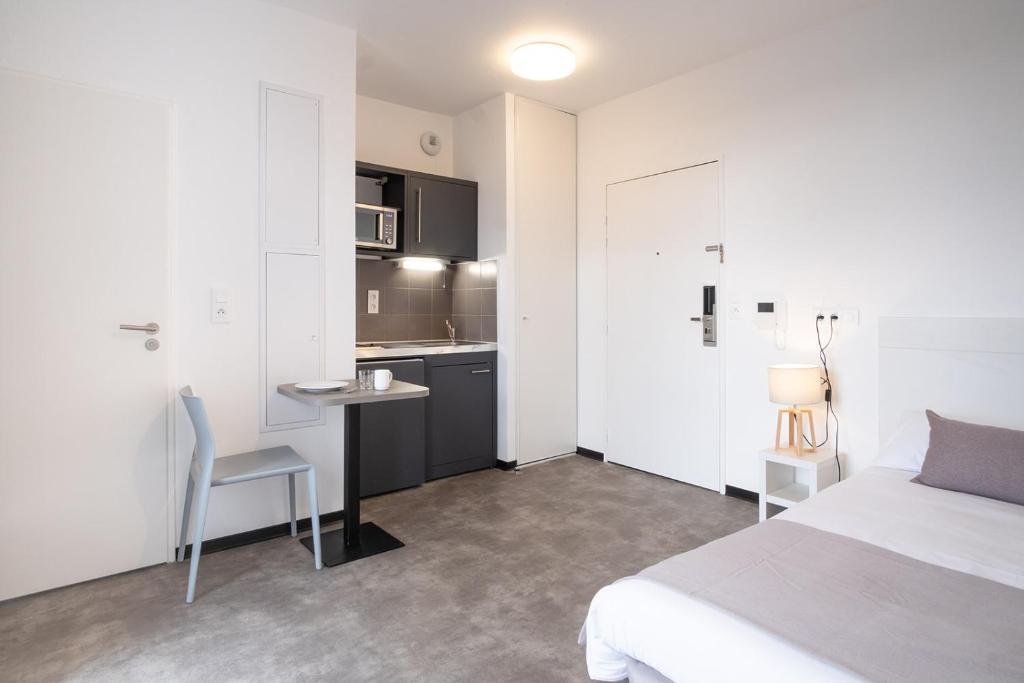 een slaapkamer met een bed, een bureau en een keuken bij Student Factory Bordeaux Armagnac in Bordeaux