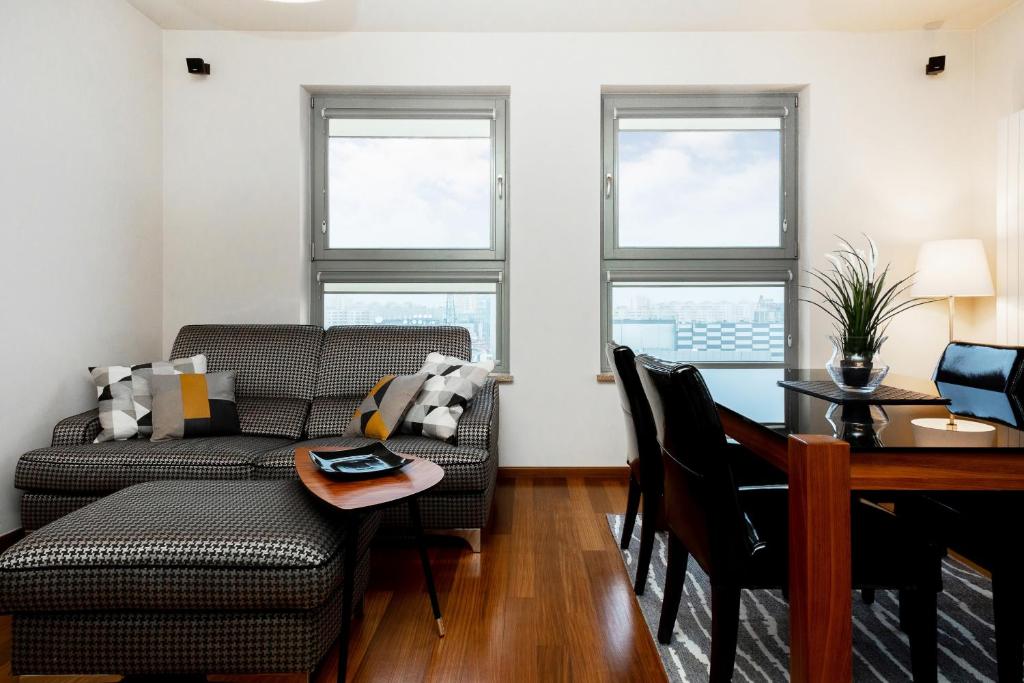 a living room with a couch and a table at Warsaw Promenada Family Apartment by Renters in Warsaw