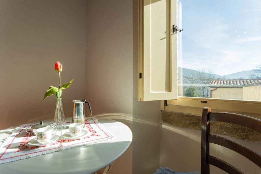 een witte tafel met een bloem in een vaas erop bij Villa Costanzi - Breezy Terrace On The Cucco in Sigillo