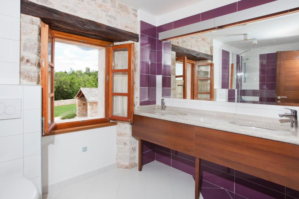 łazienka z dużą umywalką i lustrem w obiekcie Villa Poropati, Grožnjan, Istria - Luxury Countryside Estate for up to 19 persons - Large pool of 80m2 with kids section w mieście Grožnjan