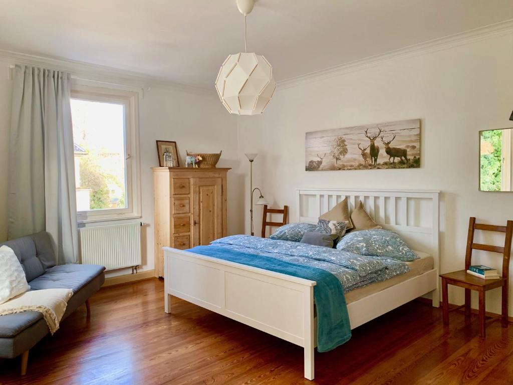 a bedroom with a bed and a couch at Deluxe Business City Apartments Metzingen Villa Landenberger in Metzingen