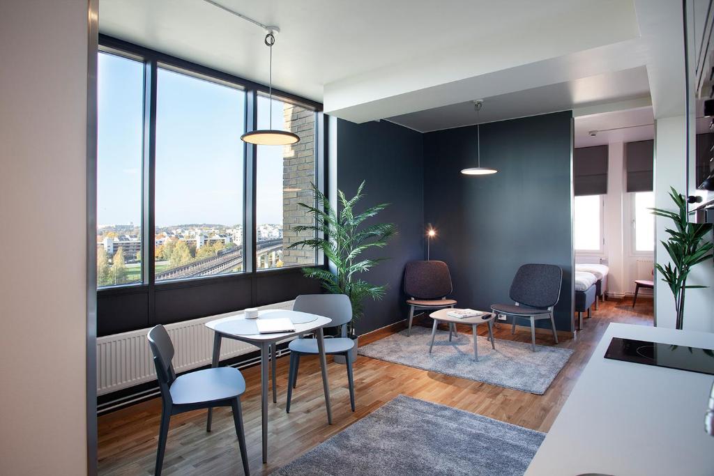 a room with a table and chairs and windows at The Studio Hotel in Stockholm