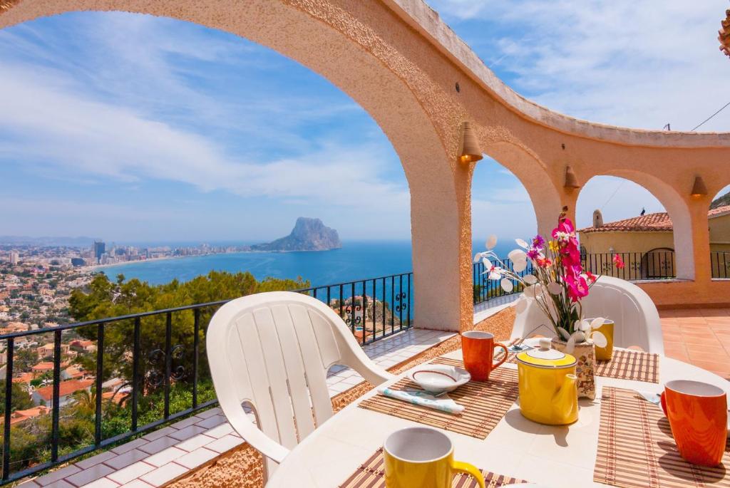 d'une table et de chaises sur un balcon avec vue sur l'océan. dans l'établissement Villas Guzman - Arcadien, à Calp