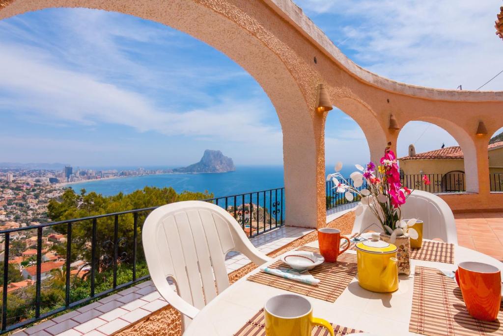 a table and chairs on a balcony with a view of the ocean at Villas Guzman - Arcadien in Calpe
