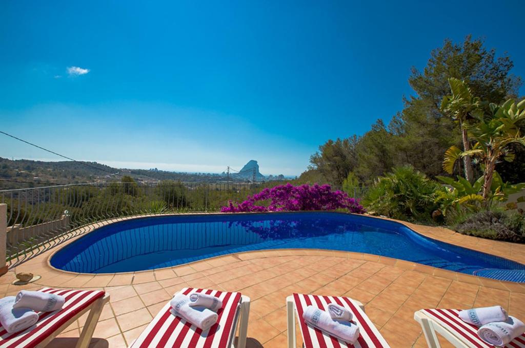 a swimming pool with two lawn chairs and a swimming pool at Villas Guzman - Carlos in Calpe