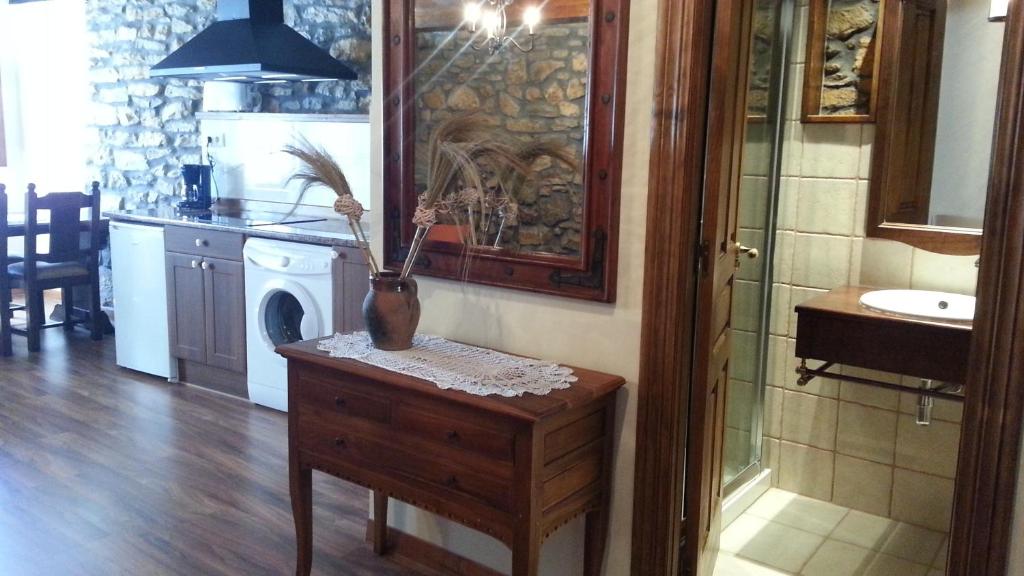 un jarrón sobre una mesa en una cocina con fregadero en Apartamentos Legado de Santillana, en Santillana del Mar