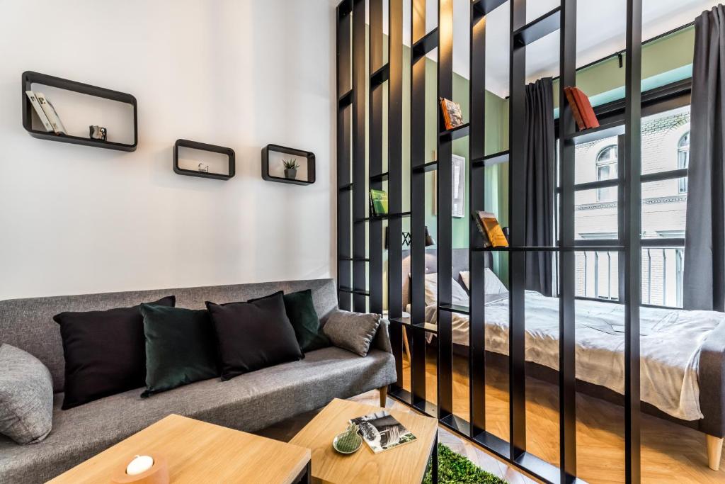 uma sala de estar com um sofá e uma cama em BpR Emerald City Apartment em Budapeste