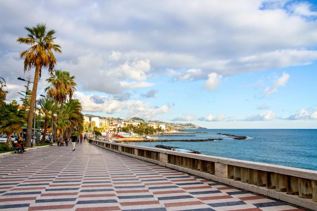 einen Bürgersteig am Meer mit Palmen in der Unterkunft Sanremo Seaside Studio in Sanremo