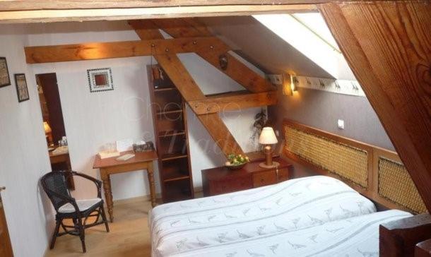 een slaapkamer met een bed en een bureau op zolder bij gite du chêne in Bierne