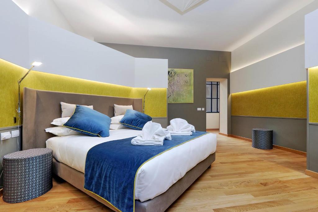 a bedroom with a large bed with blue and white pillows at Colonna 32 in Rome