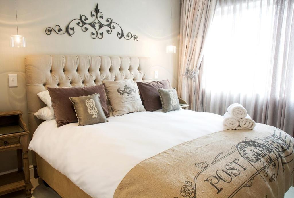 a bedroom with a large white bed with pillows at Avemore Lagratitude No 6 - with backup power for loadshedding in Stellenbosch