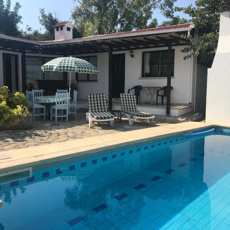 a house with a swimming pool and a patio at Hidden Cottage in Kyrenia