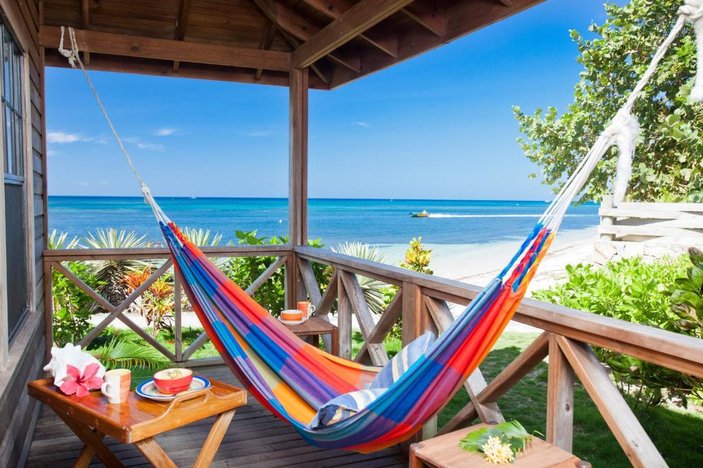 a hammock on a porch overlooking the beach at Las Rocas Resort and Dive Center in West Bay