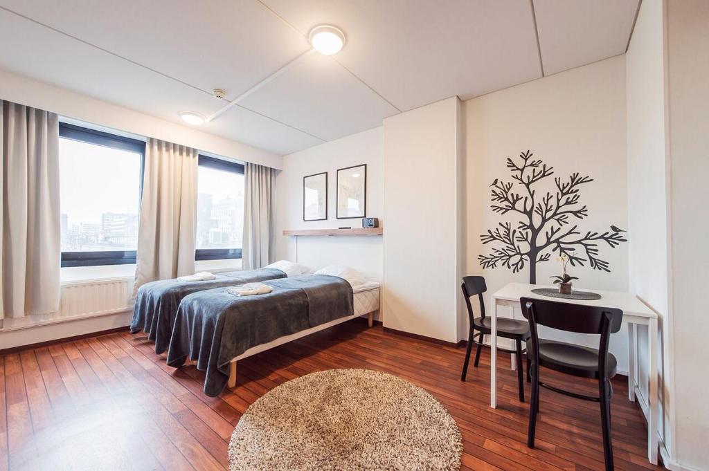 um quarto com uma cama, uma secretária e uma mesa em Forenom Aparthotel Lahti em Lahti