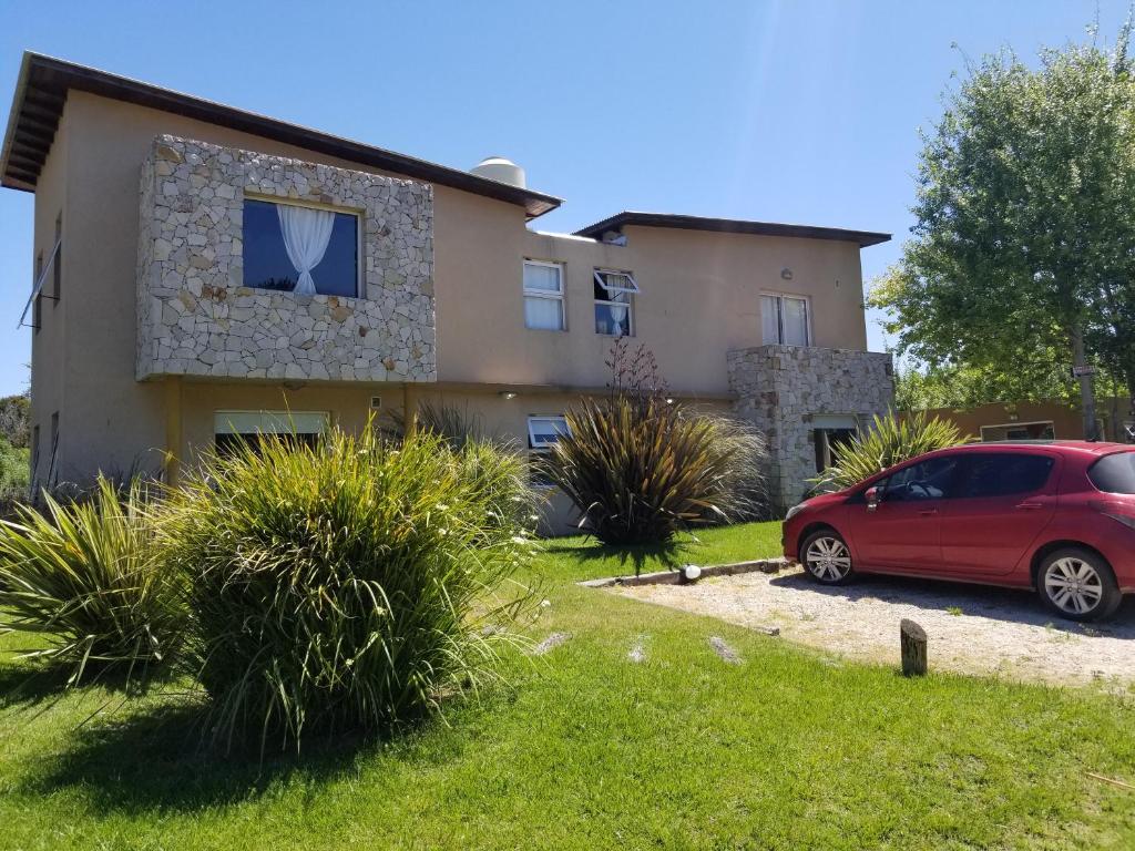 una casa con un coche rojo estacionado frente a ella en Princesas Del Mar a 4 cuadras del mar en Balneario Mar Azul