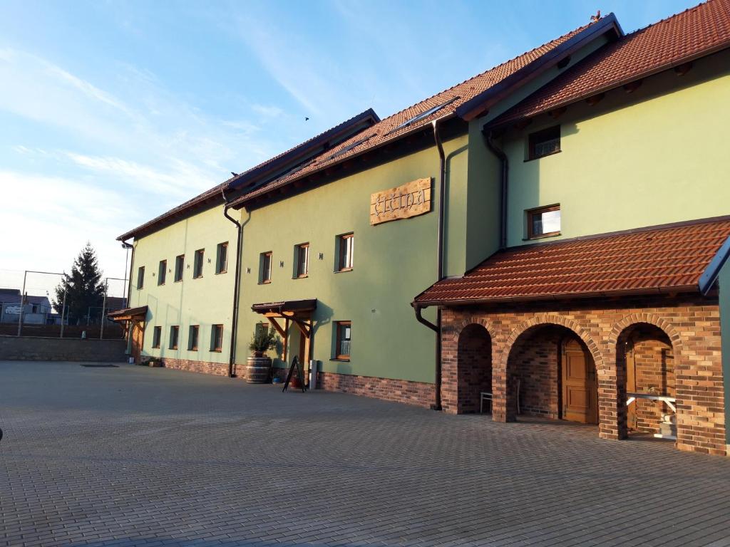 a building on a street with a cobblestone street at Čičina Tvrdonice penzion, restaurace, vinný sklep in Tvrdonice