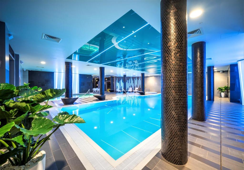 a large swimming pool in a large room at Wellton Riverside SPA Hotel in Riga