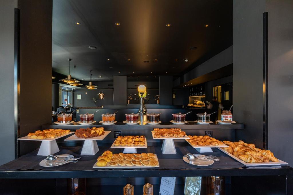 a buffet line with many different types of pastries at Evidencia Belverde Hotel in Amora