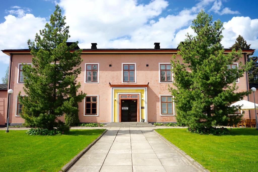 a large pink house with two trees in front of it at LentoHotelli in Kauhava