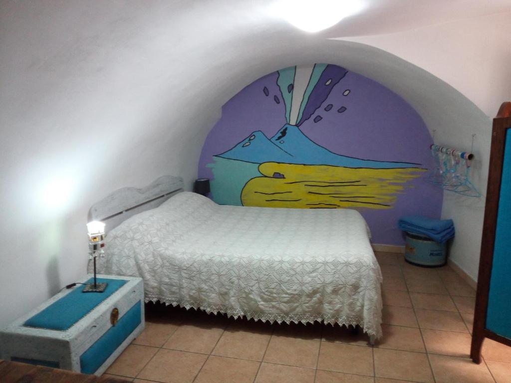 um quarto com uma cama com um quadro na parede em La Casetta em Nápoles